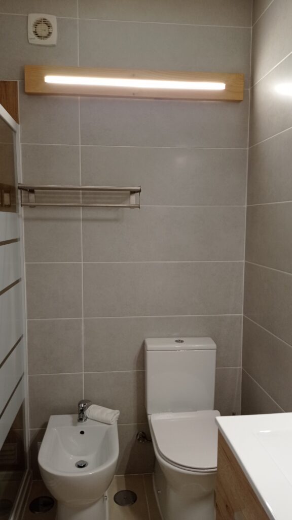 Moderní koupelna s bidetem a záchodem a šedými kachlíčky