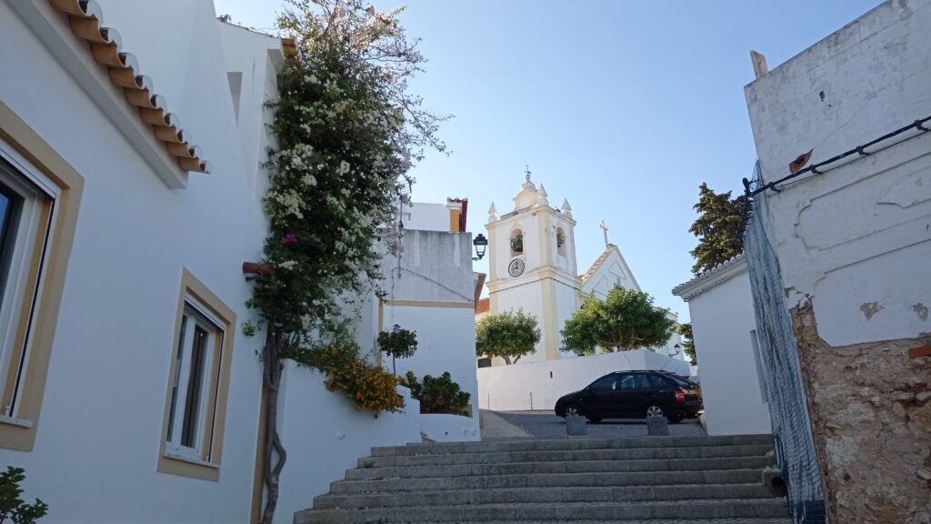 malebná vesnička se schodištěm a kostelíkem v dálce