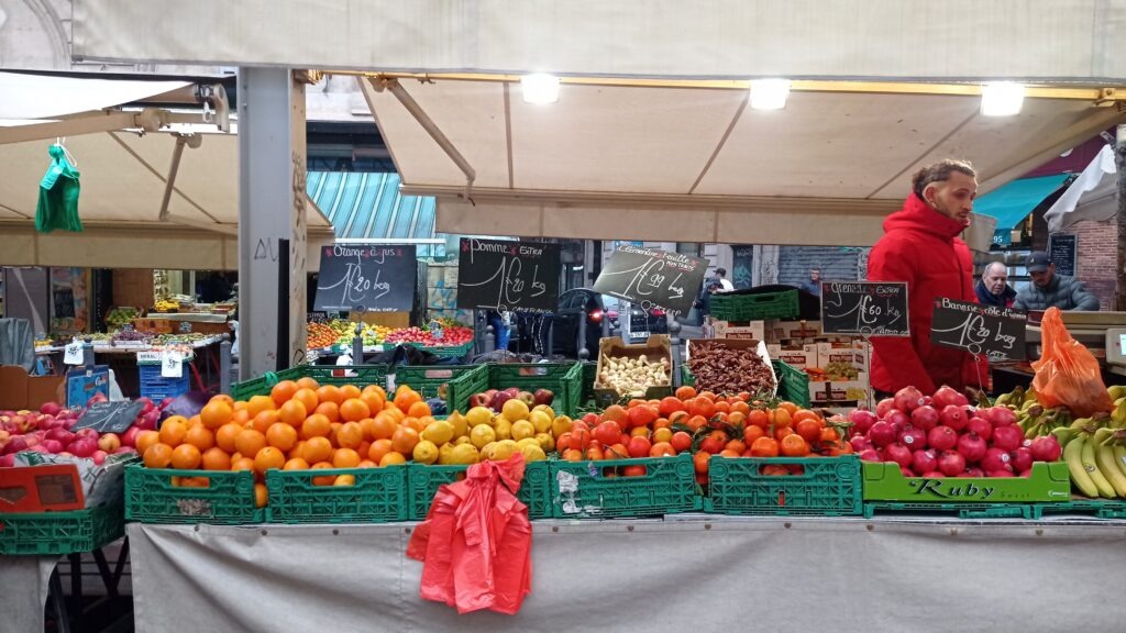 tržnice s ovocem a prodavač v červené bundě