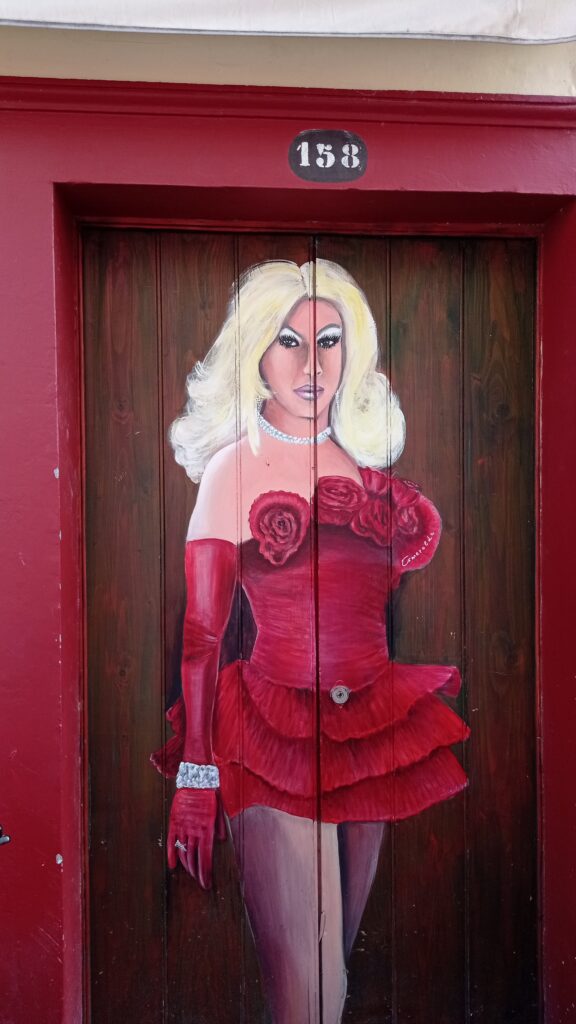 Dveře na kterých je namalovaná pani s blond vlasy a červenými šaty