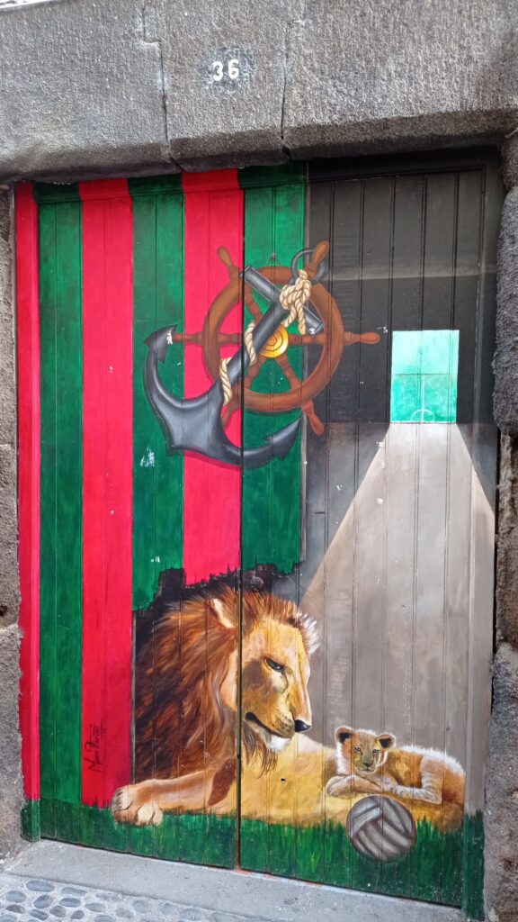malované vrata s kotvou, kormidlem a lvem s lvíčetem