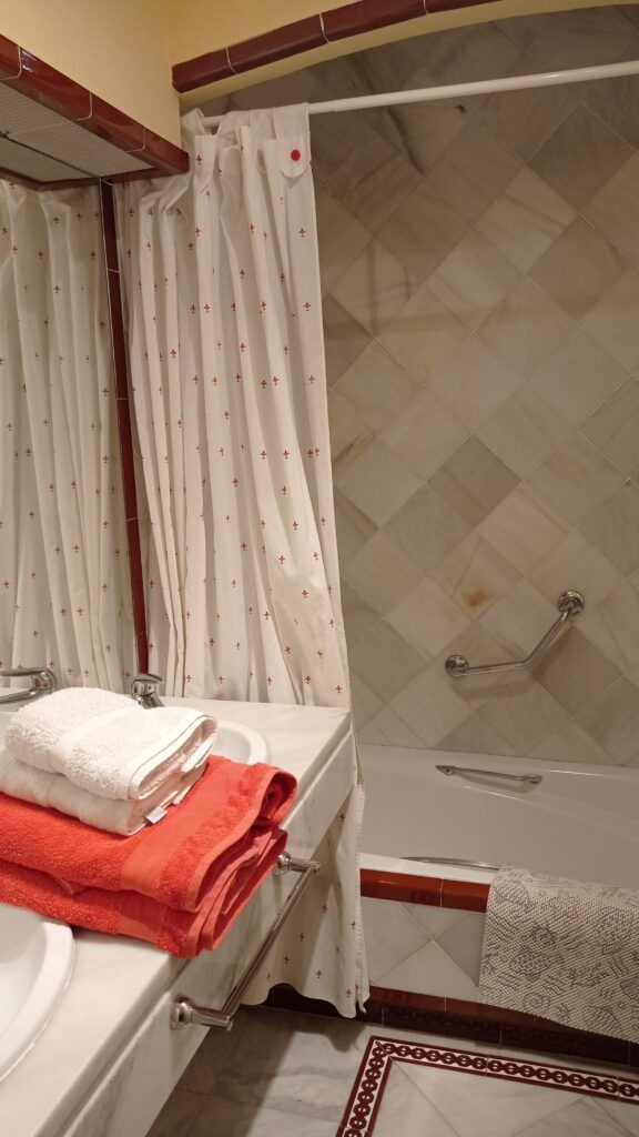 koupelna s vanou a červené osušky a bílý ručník