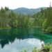 Horské jezero tyrkysové barvy a jehličnaté stromy