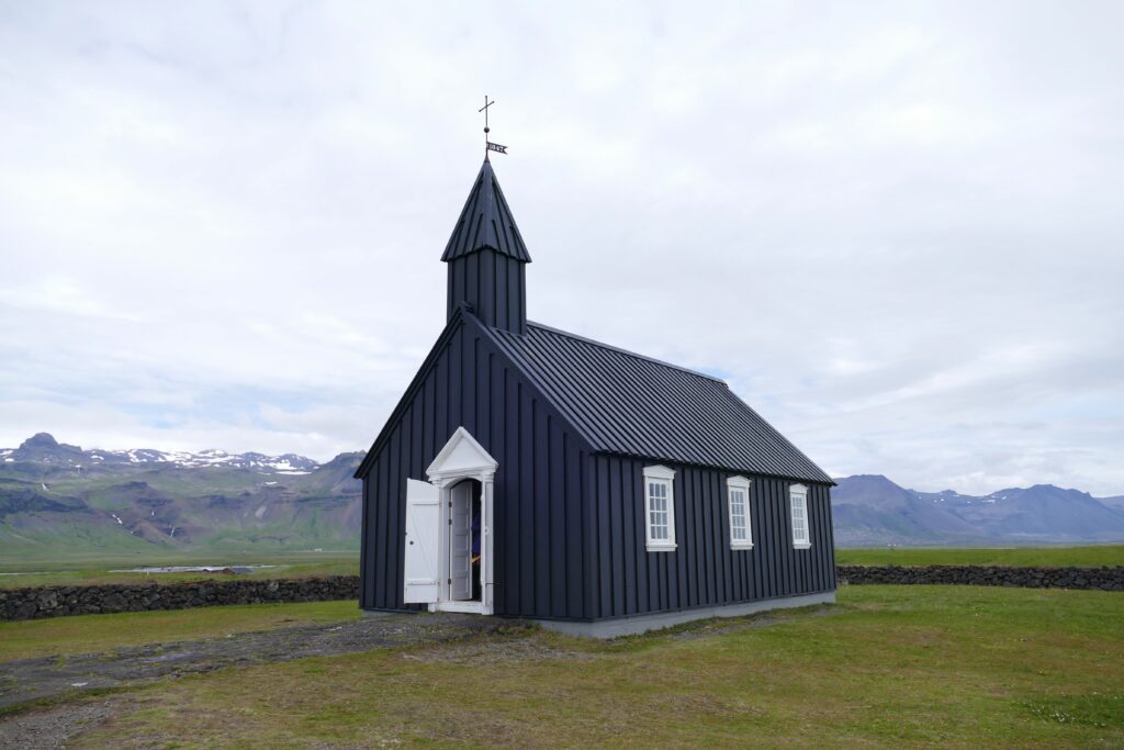 Černý kostelík s bílými dveřmi a okny