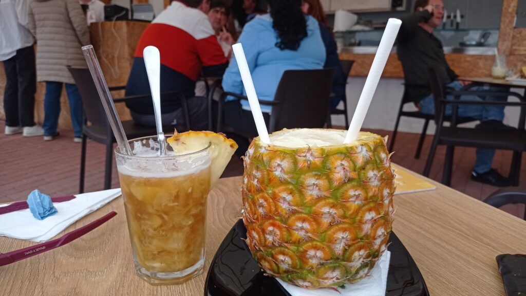 sklenice s pitím a ananas se dvěma brčky