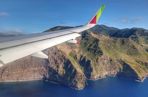 pohled z letadla na křídlo letadla a skalnaté pobřeží ostrova Madeira