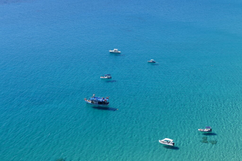 Tyrkysové moře na Sardinii s šesti loďkami
