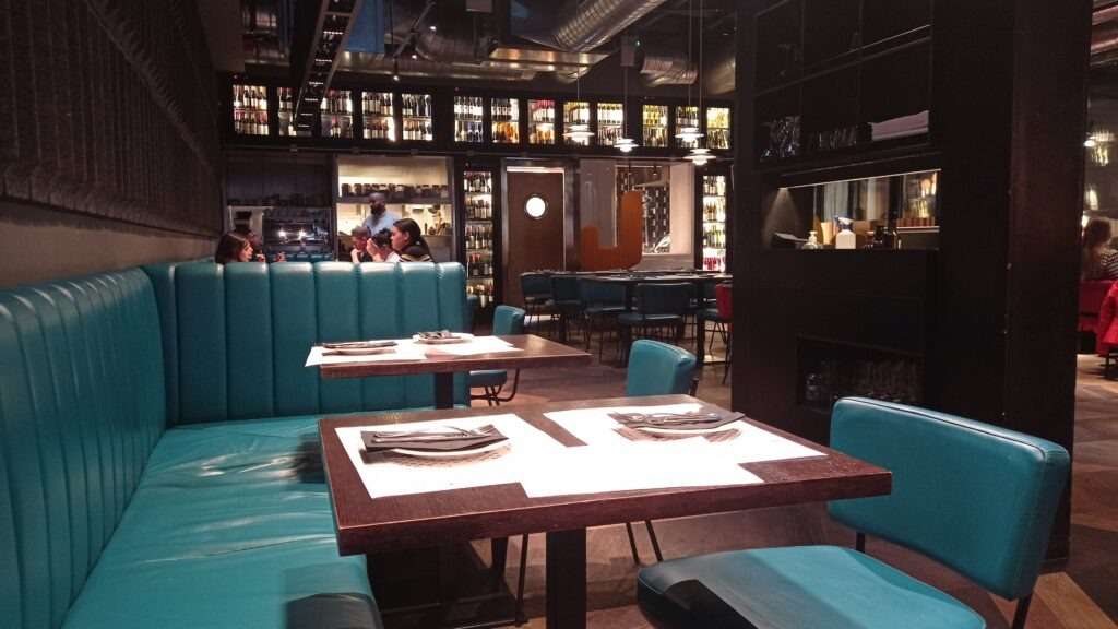 Interiér restaurace s tyrkysovými sedačkami