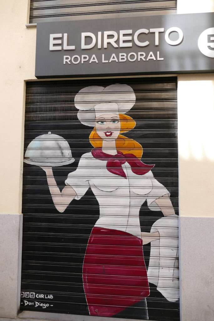 Street art, malba na stahovací roletě kde je servírka s podnosem