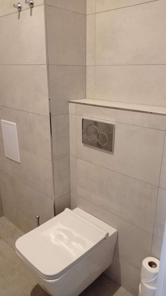 Bílý záchod a moderní šedé kachlíky