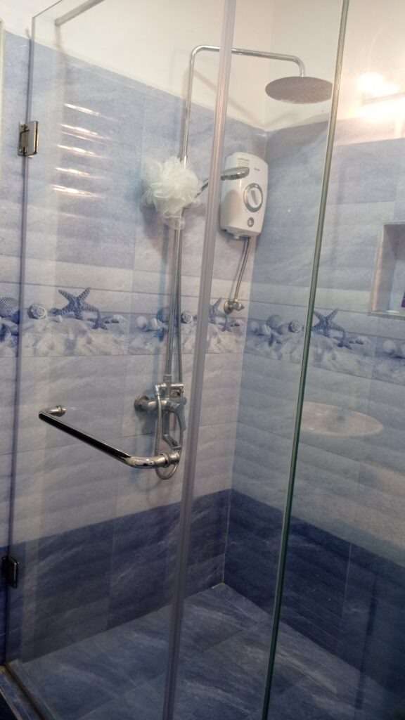 Koupelna se sprchovým koutem a bílo modrými kachlíčky