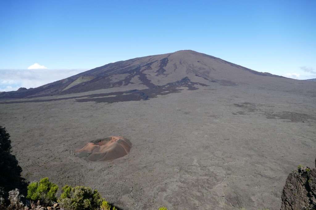 Malý sopečný kráter a vzadu velká sopka