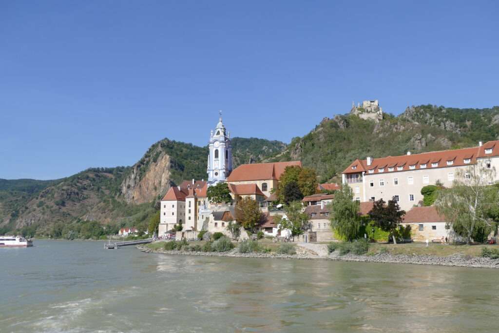 Pohled z lodi na řeku a malebné městečko