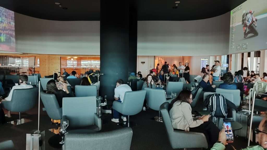 Letištní salonek s cestujícími odpočívajícími před odletem
