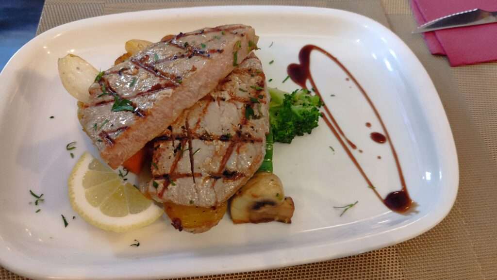Steak z tuňka na bílém talíři