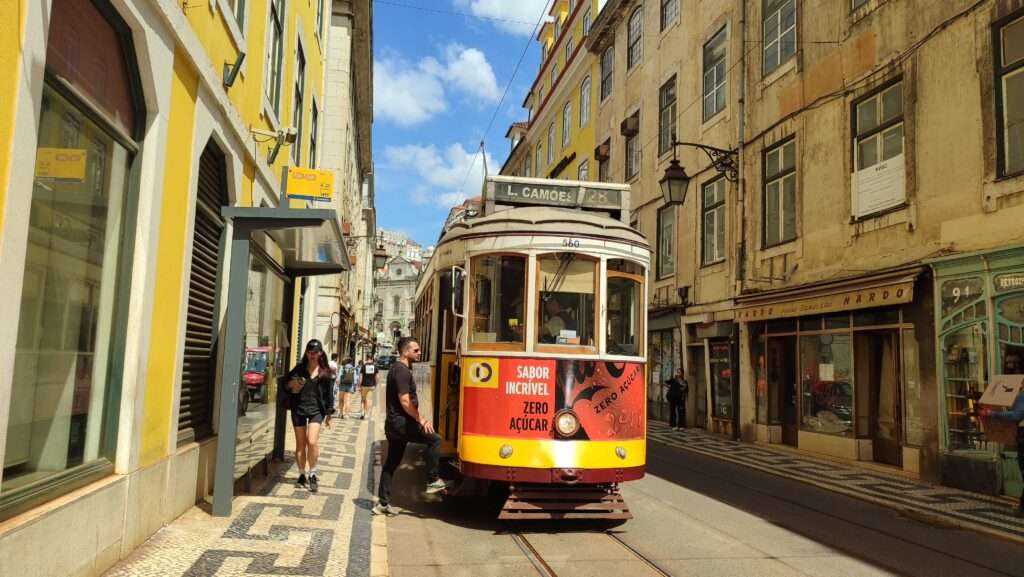 Klasická historická tramvaj číslo 28 projíždějící historickým centrem Lisabonu