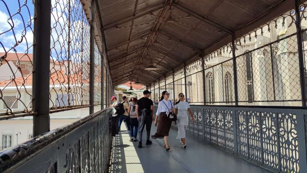 Turisté procházející krytou galerií výtahu Santa Justa v Lisabonu