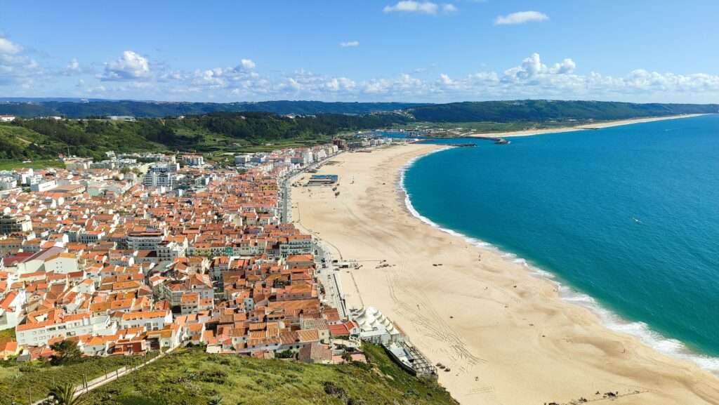 Pohled na město Nazaré s písečnou pláží a oceánem