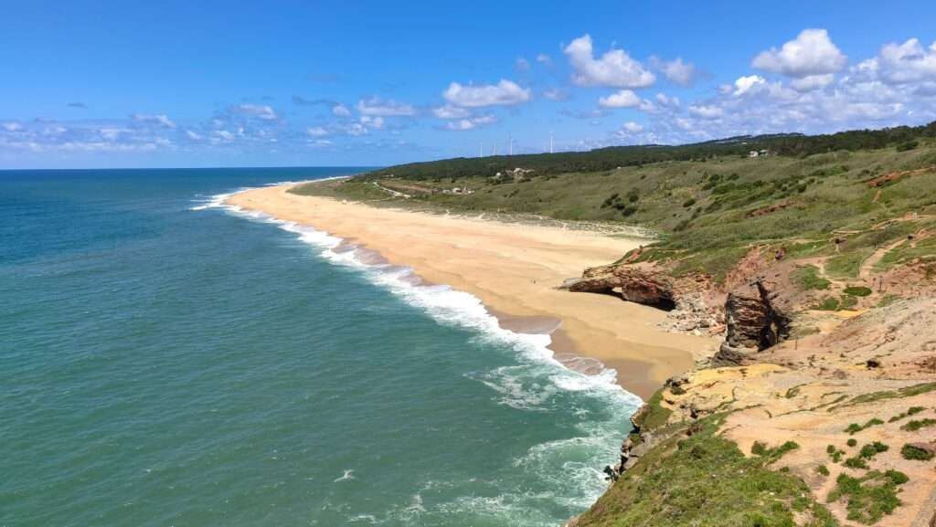 obřeží s dlouhou písečnou pláží u Nazaré v Portugalsku