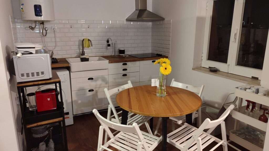 Kuchyň s jídelním koutem a květinovou výzdobou v portugalském apartmánu