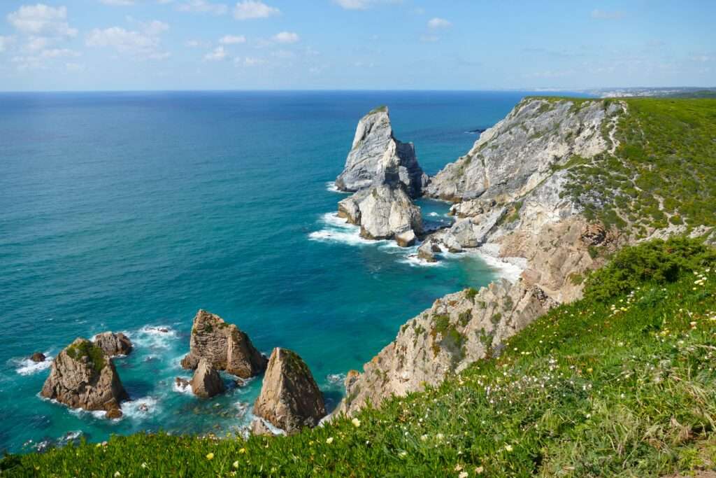 Pláž Praia da Ursa s dramatickými skalními útvary u oceánu