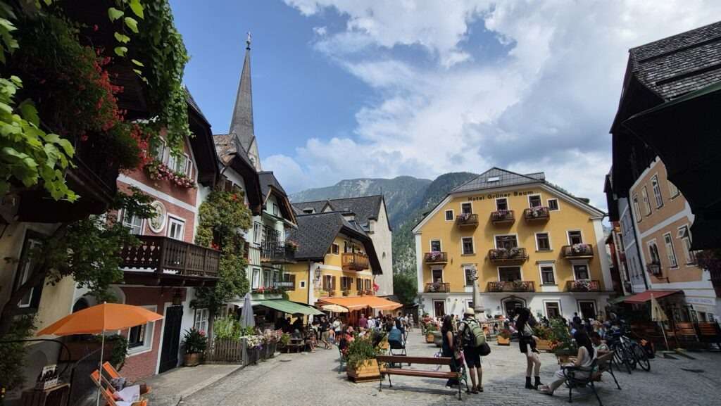Malebné náměstí v Hallstattu s kavárnami a turisty
