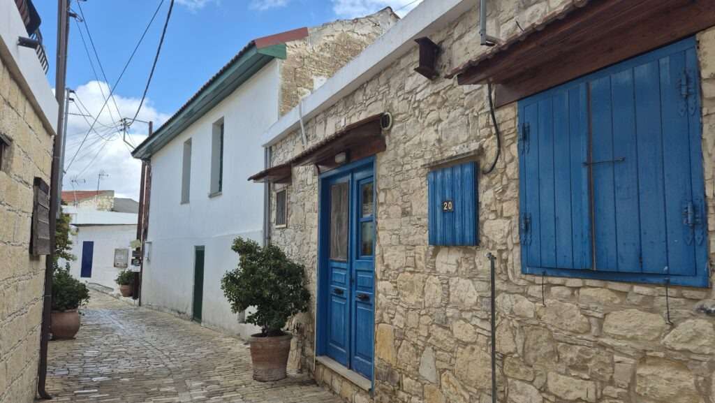 Kamenné uličky a modré dveře tradiční vesnice Omodos