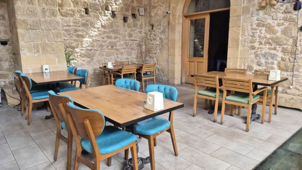 Kamenná restaurace s typickou atmosférou a dřevěnými stoly.