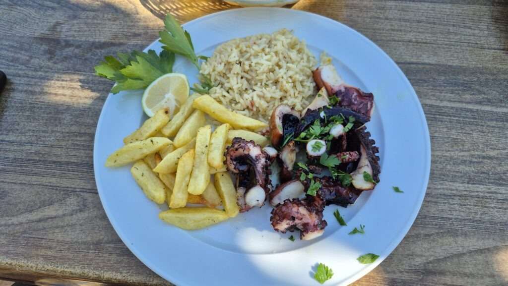 Grilovaná chobotnice s hranolky – typické jídlo v kyperské taverně u moře.