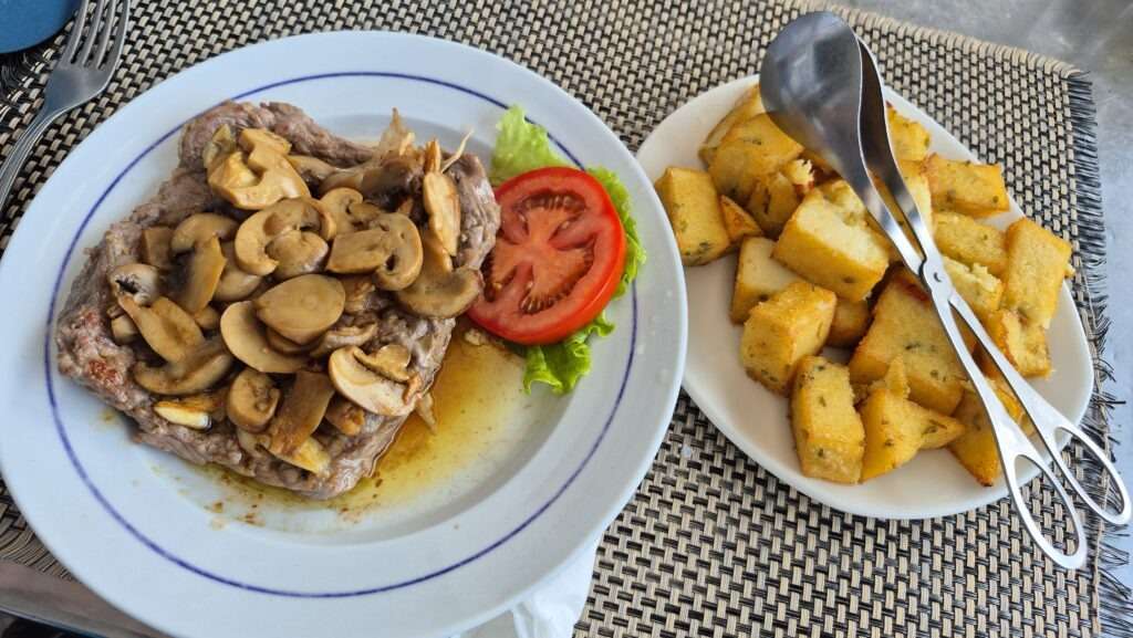 Grilované maso s bramborami a salátem v Restaurante Os Amigos v Ponta do Sol