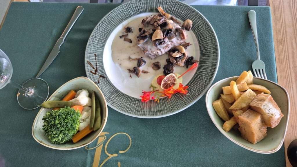 Steak s houbovou omáčkou a na misce hranolky a zelenina