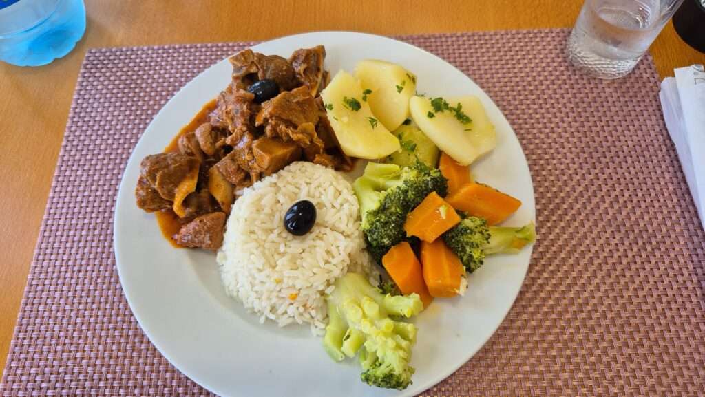 Kozí maso s rýží, masem a zeleninou v restauraci Sol Posto v Canhas